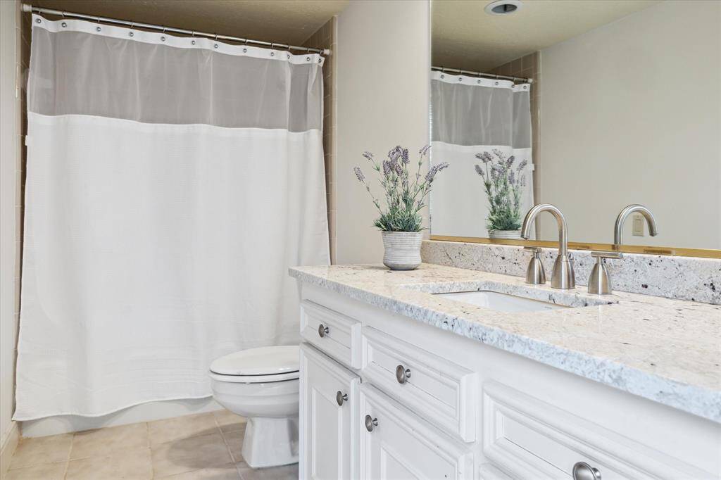 Sharing the 3rd floor with the primary bedroom is this very spacious secondary bedroom with soft gray walls, a large window with sheer curtains allowing natural light, and neutral carpet flooring.