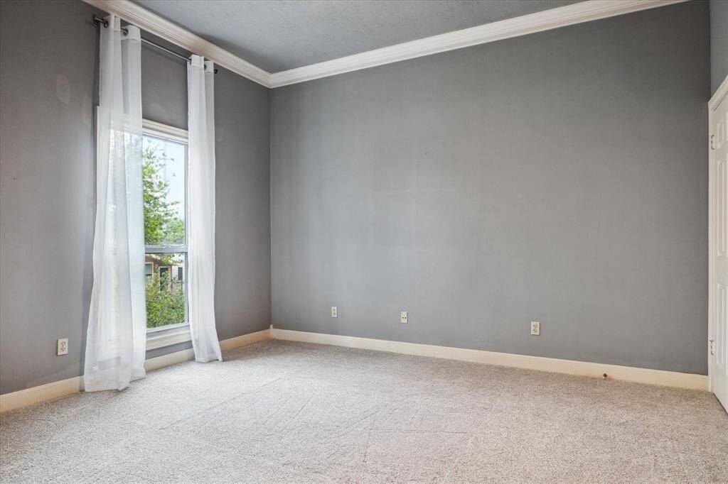 The private bath for the secondary bedroom on the 3rd floor features a light, modern granite countertop, modern fixtures, and ample storage. Natural light streams through sheer curtains.
