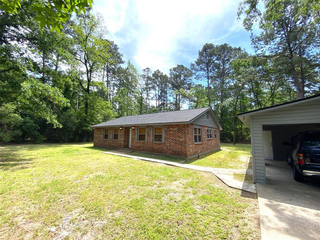 Front view of the home from the driveway.  To the left you see the 1 car carport with storage.