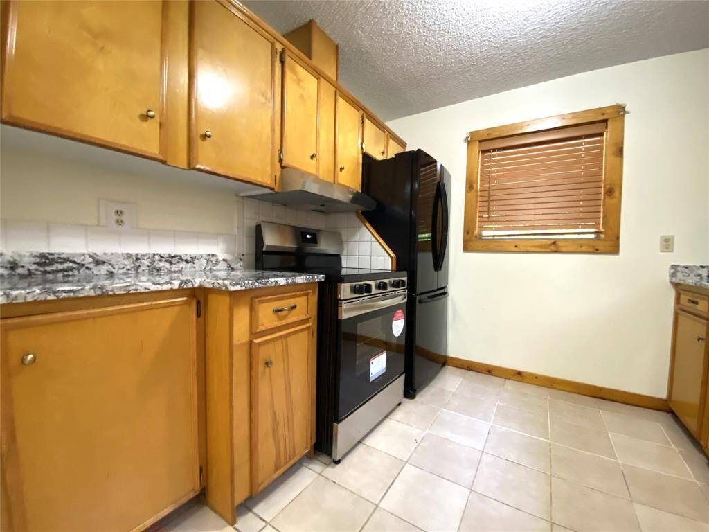 New electric range and refrigerator with freezer at the bottom.