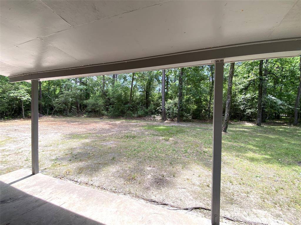 Under the covered patio looking to the back yard.  Look at all the beautiful trees in the rear of the property.