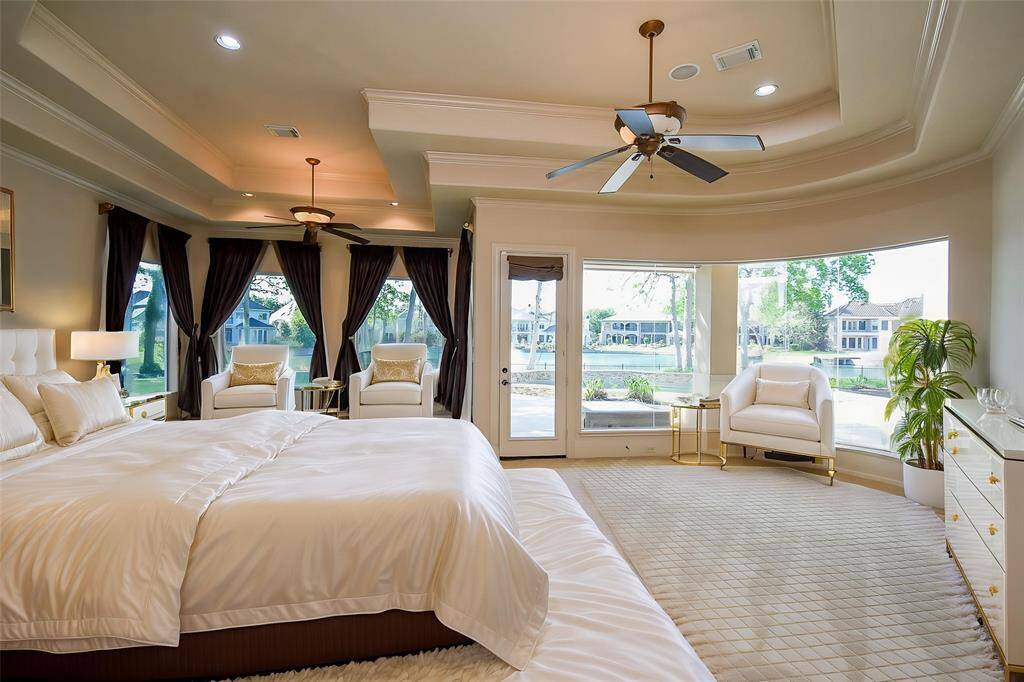 Primary Bedroom Virtual Staging: Raised sitting area with amazing lake, pool, and backyard views. See-through fireplace to the Primary Bathroom.