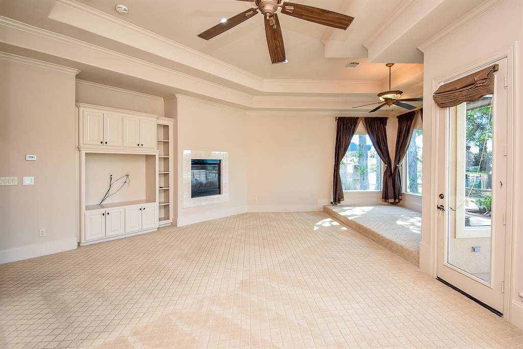 huge primary bedroom.  Note two way fireplace, elevated sitting area and door leading out to backyard oasis.