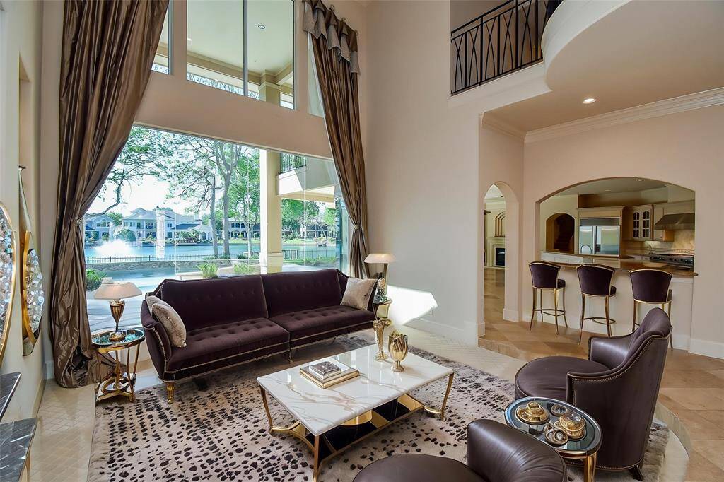 Living Room with two story floor to ceiling glass looking out at the pool and water!  (Virtually Staged)