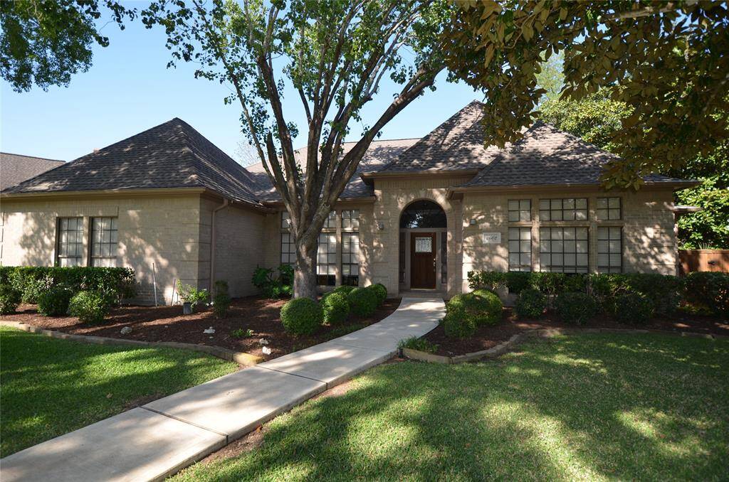 Front of house shaded by mature trees, sidewalk has been replaced recently