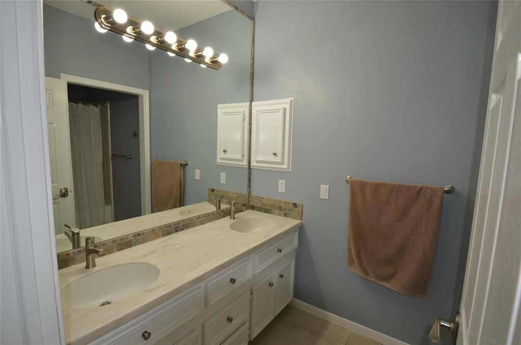 Front bedroom features private bath with double sinks and custom cabinets