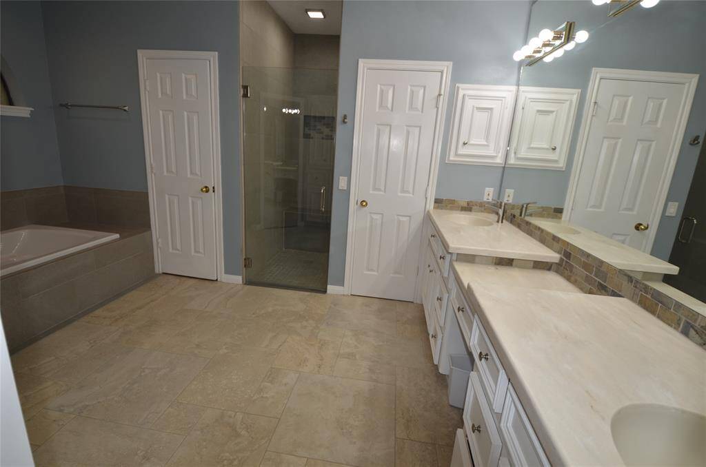 Full bath with double sinks and dual walk-in closets