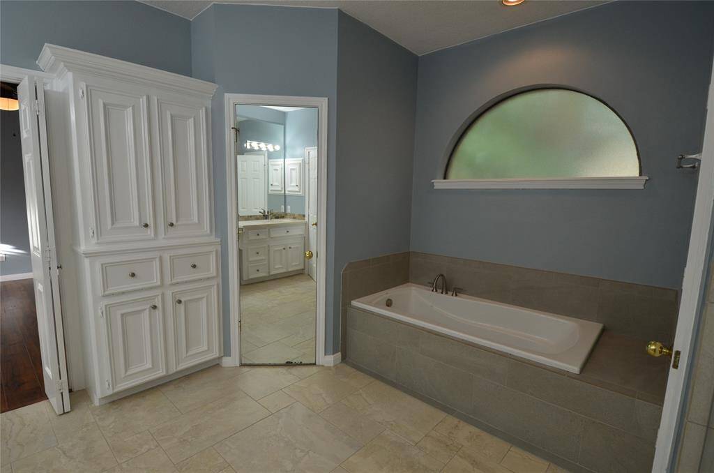 Large soaking tub with separate water closet and large custom cabinet storage