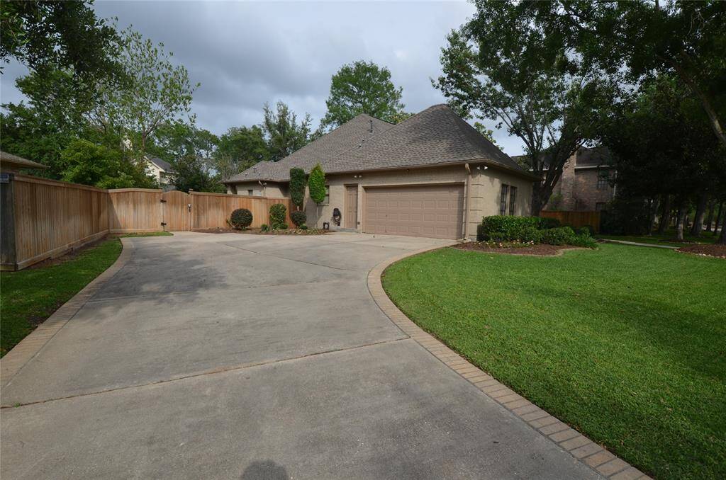 Two-car garage with built cabinet with extra driveway parking with large gate access to backyard
