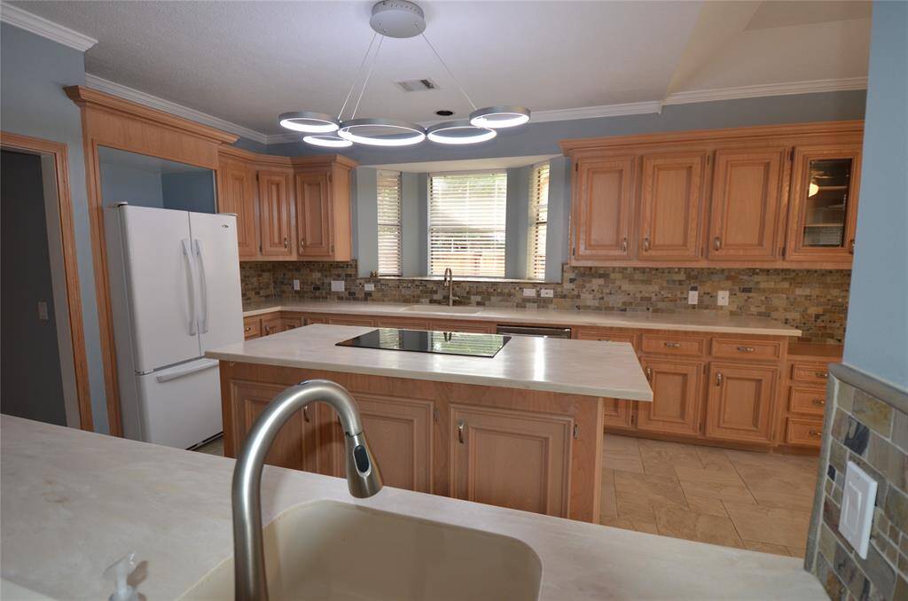 Kitchen features large sink with motion sense faucet and bay window to side yard