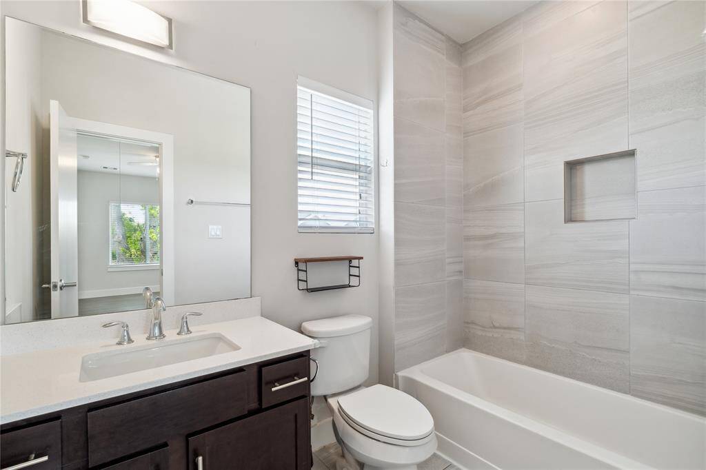 Your secondary bathroom, with a shower niche and large tiles that go up to the ceiling.