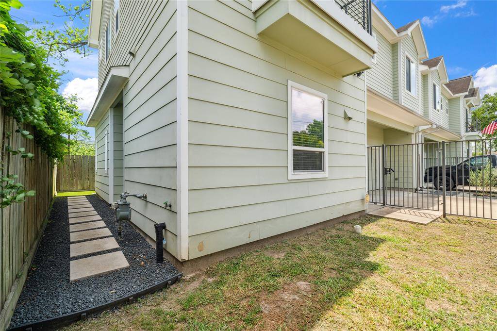 A view of your privately gated front yard, side yard with large pavers and a view of your turfed backyard.