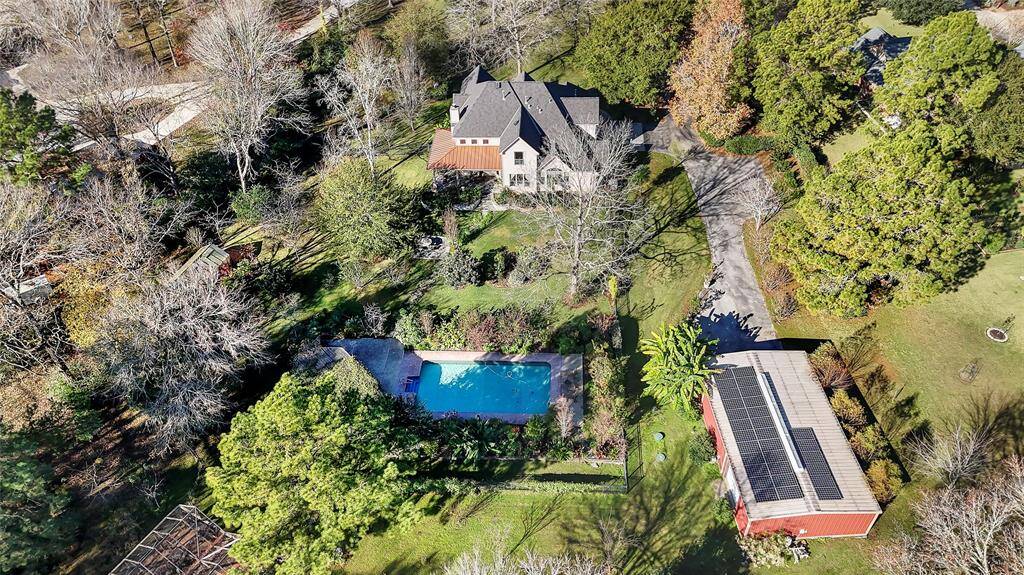 Backyard view of home, pool, workshop & greenhouse
