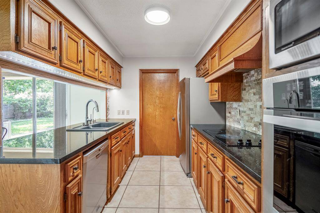 Welcome into this adorable galley kitchen with plenty of storage and a wall mounted microwave and oven. Through the closed door is your utility room.