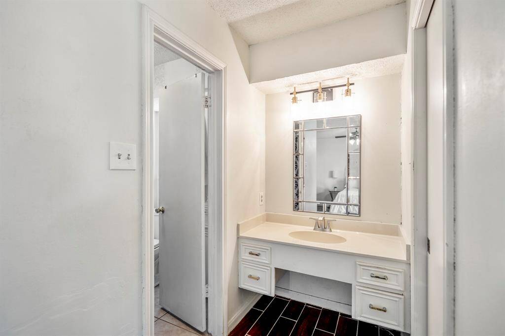 This adorable vanity greets you in the primary bathroom with a water closet and shower to the left and a closet to the right.