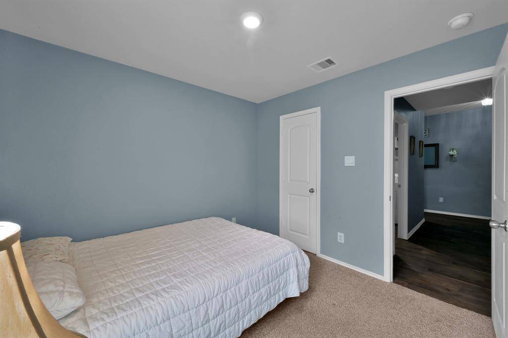 Alternative view of the secondary bedroom on the left front side of the home. (Laundry room located to the left and garage located to the right)