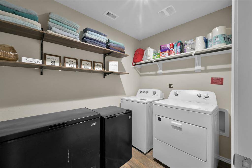 Check out the oversized laundry room with extra space for a deep freezer. It also has additional shelving for storage.