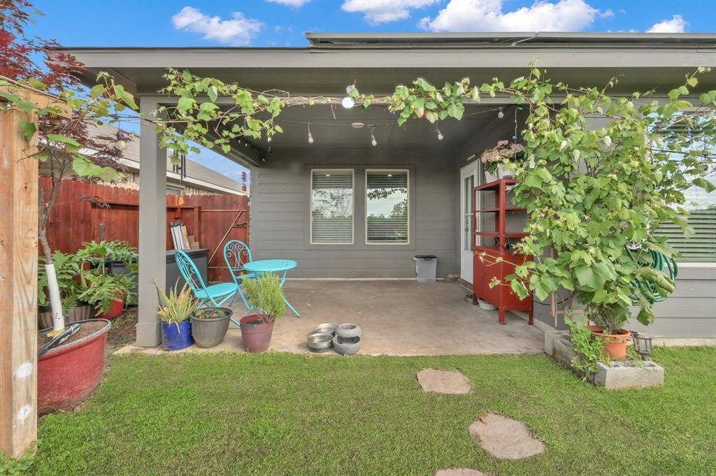 The spacious back patio is just the beginning of this beautiful backyard. The vining plant along the back is actually a grape vine.