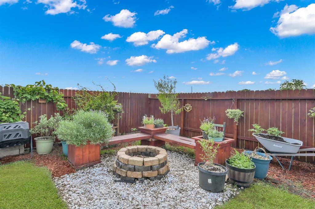 Not only is this backyard a gardeners dream, but it features a stone fireplace with built in seating waiting for your social gatherings.