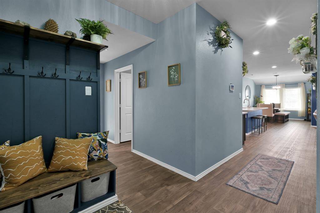 To the left of the entry you'll find a custom mud bench with storage cubbies, hooks, and a dark walnut stained shelf. (To the left is an oversized laundry room, a bedroom, and access to the garage.)