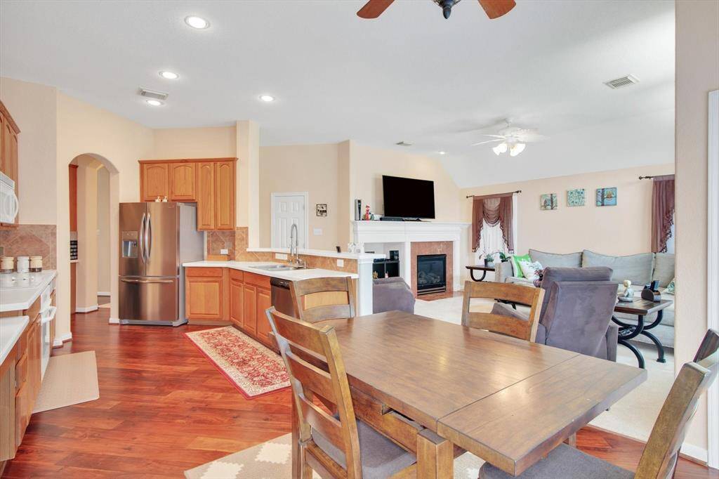 An open-plan living area with a cozy kitchen featuring stainless steel appliances and wood cabinetry.
