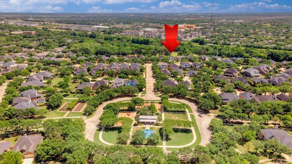 Charming neighborhood with tree-lined streets and a communal park featuring a pool. The area has well-kept homes and is close to local amenities.