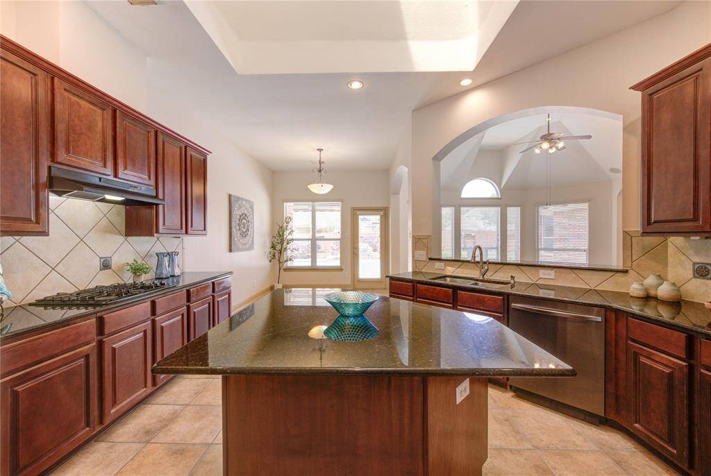 Cooking is a breeze with loads of prep space and an amazing layout. A tile backsplash and complementary granite countertops give a cohesive feel in this gourmet kitchen.