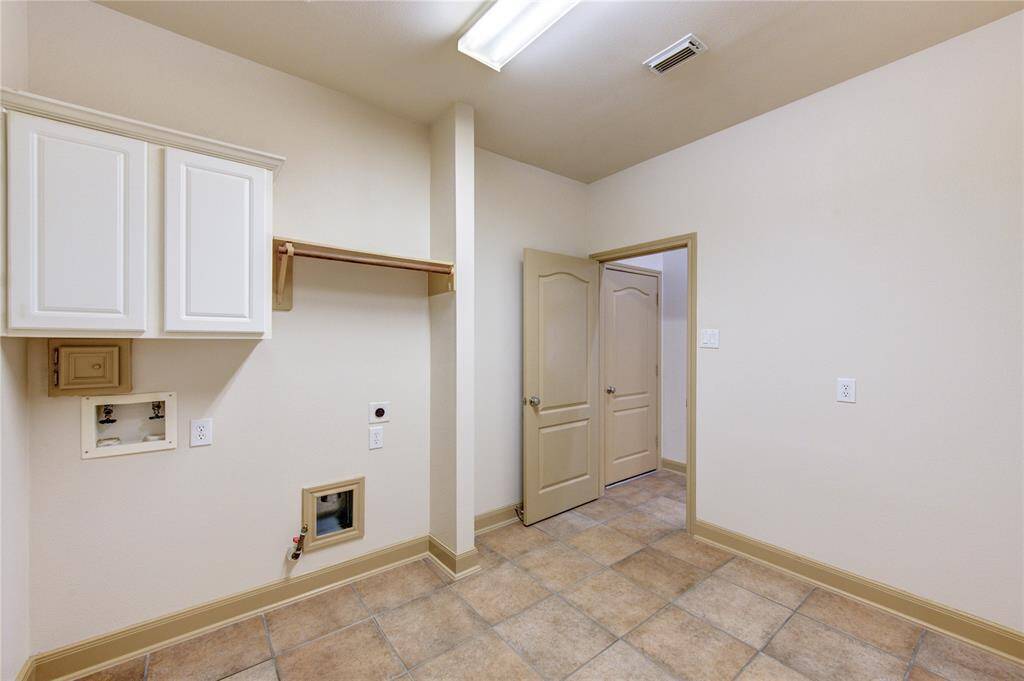 Spacious laundry room with plenty of storage- perfect for keeping everything organized and out of sight.