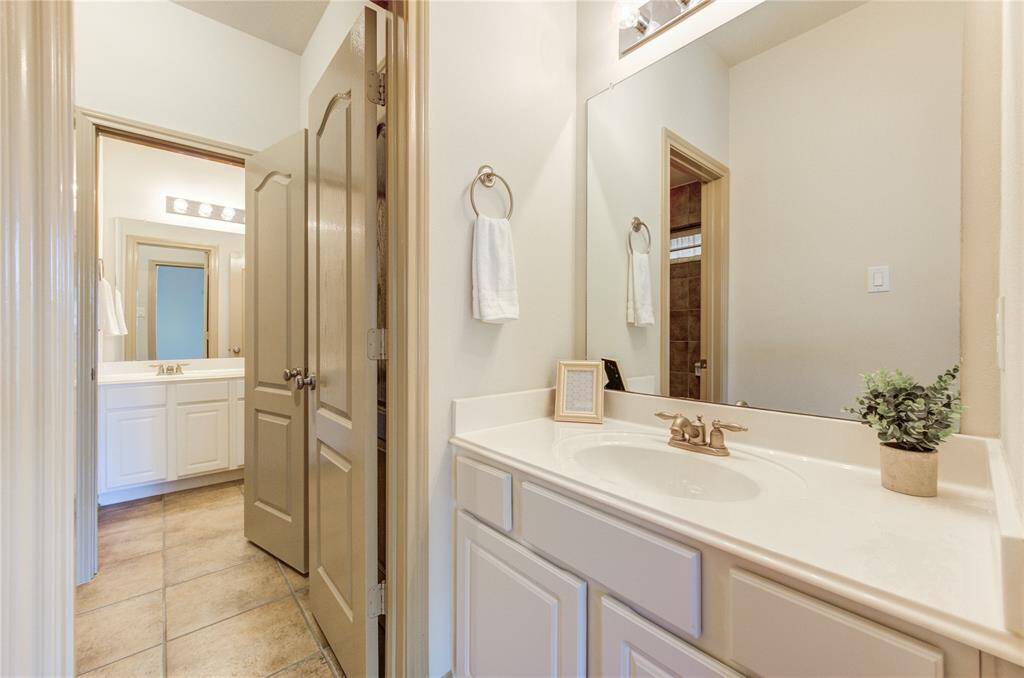 Stylish Jack and Jill bathroom with shared access, featuring a double vanity and private bath area.