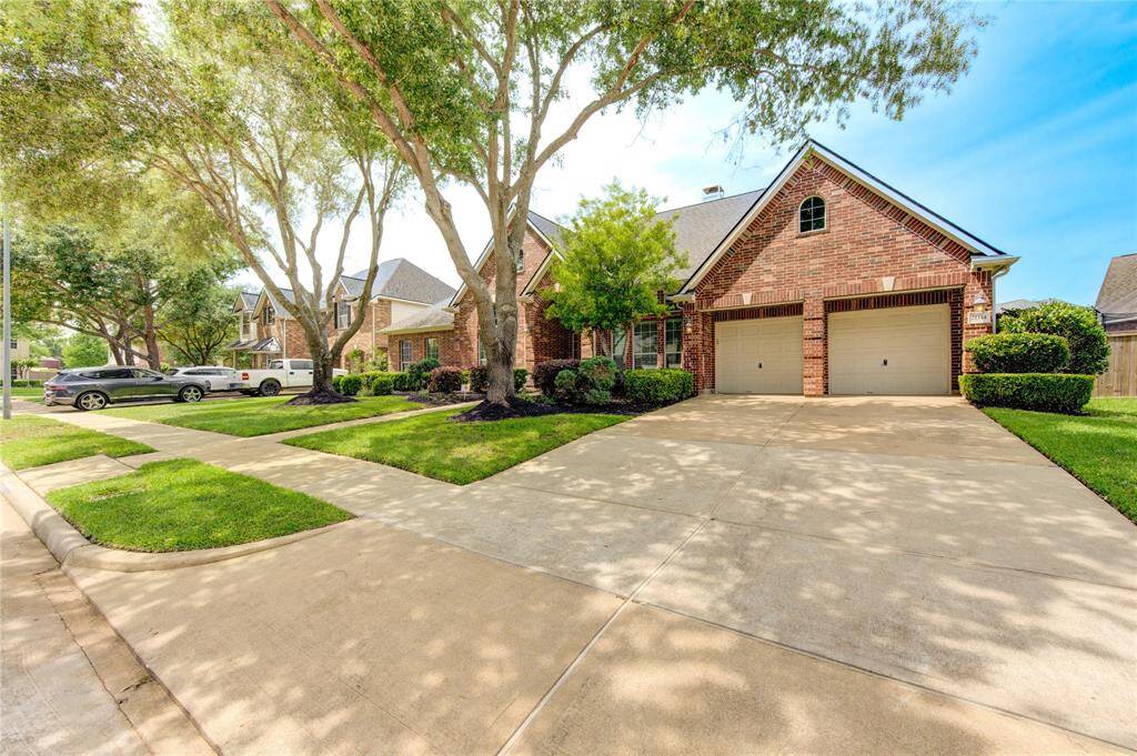 Large driveway leads up to a spacious 3-car tandem garage—plenty of room for parking and storage.