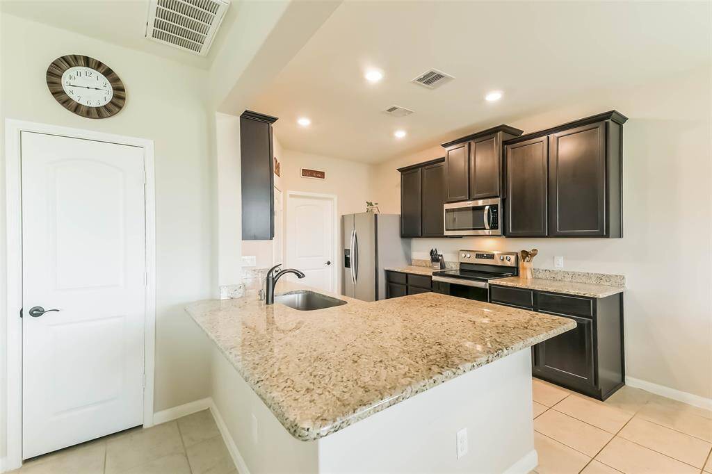 Dark cabinetry in kitchen with granite countertops