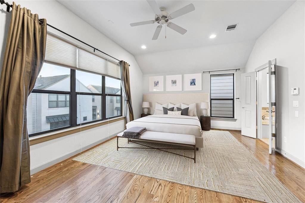 An ideal oversize primary suite lined with nearly floor to ceiling windows allowing for a plethora of natural light, continued hardwood floors and plenty of room for workout area, nursery nook or office desk. Digitally staged image*