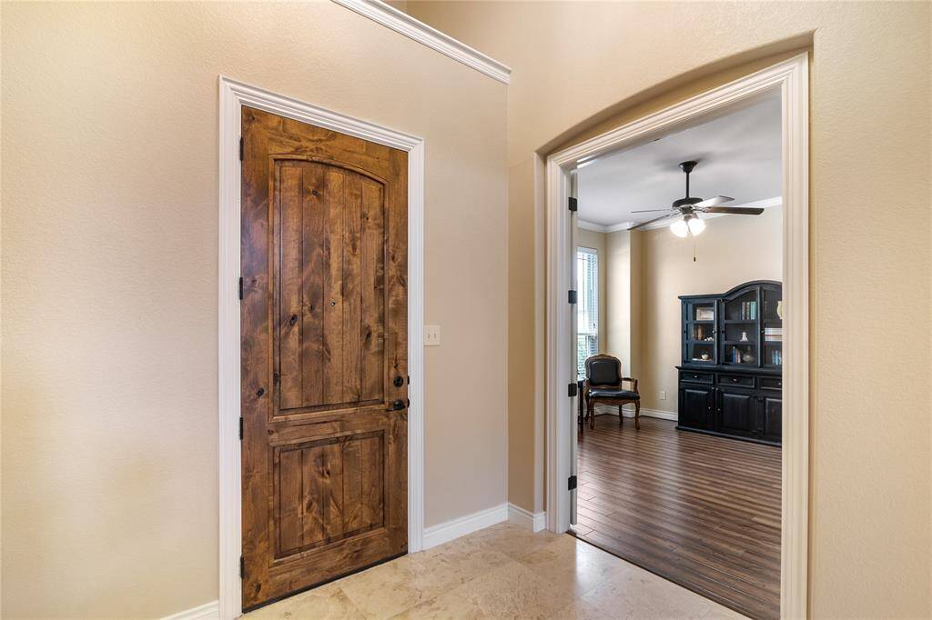 Elegant travertine flooring entering this gorgeous home. The office is ideally located at the left side coming in.