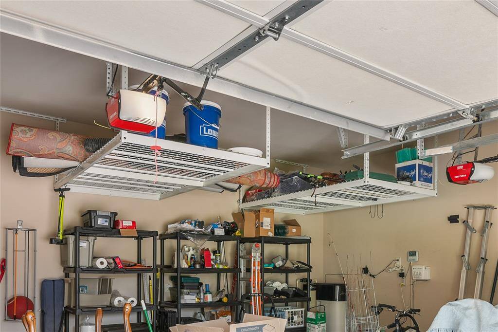 The garage features overhead storage racks and the whole house water softener.