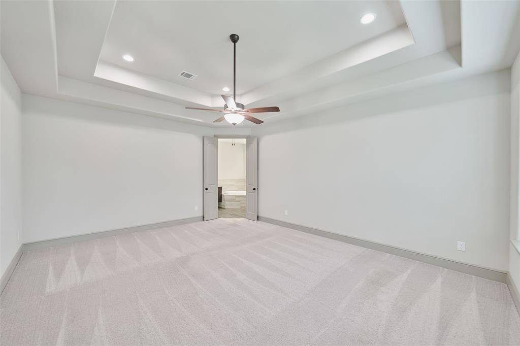 Primary bedroom with accent lights in tray ceiling.