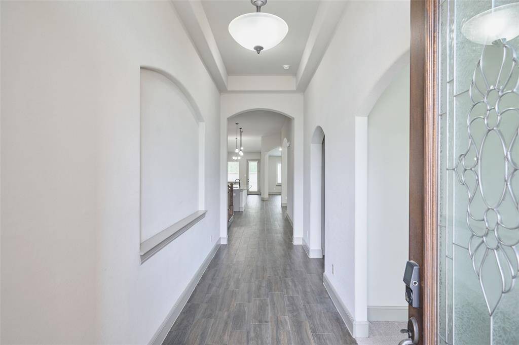 Grand entry with office to the right, then secondary bedroom and bath to right, two more bedrooms, bath, and laundry to left before kitchen.
