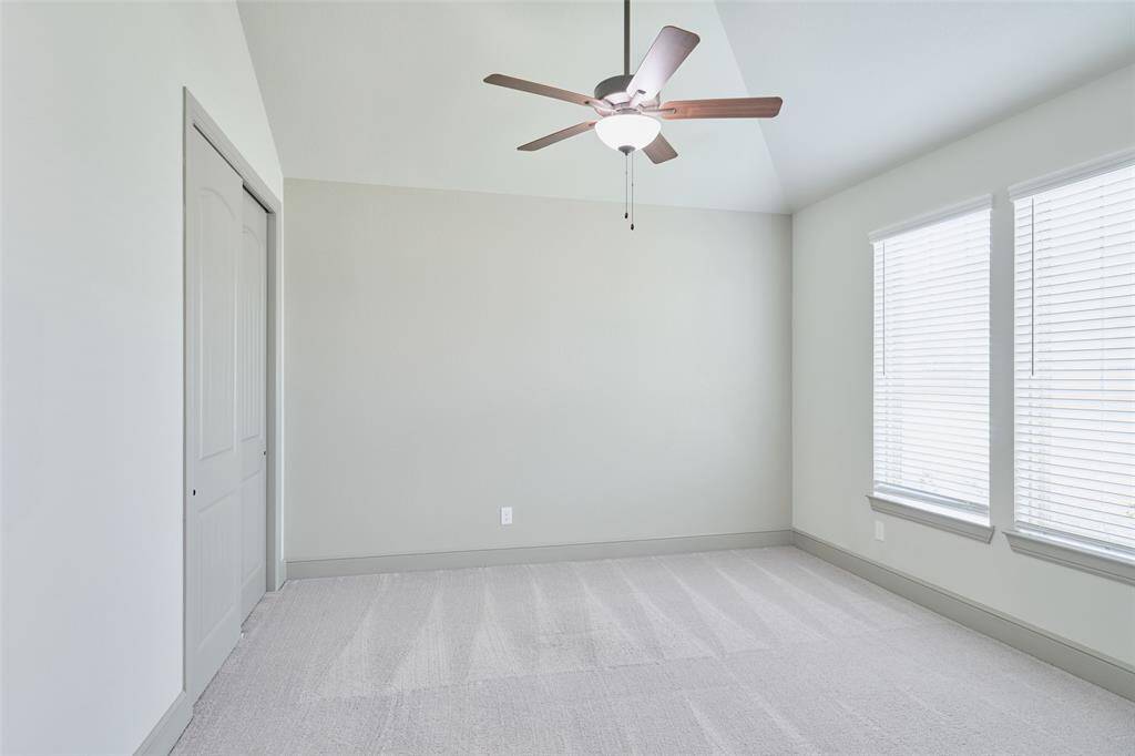 Secondary bedroom with high ceilings and large closet.