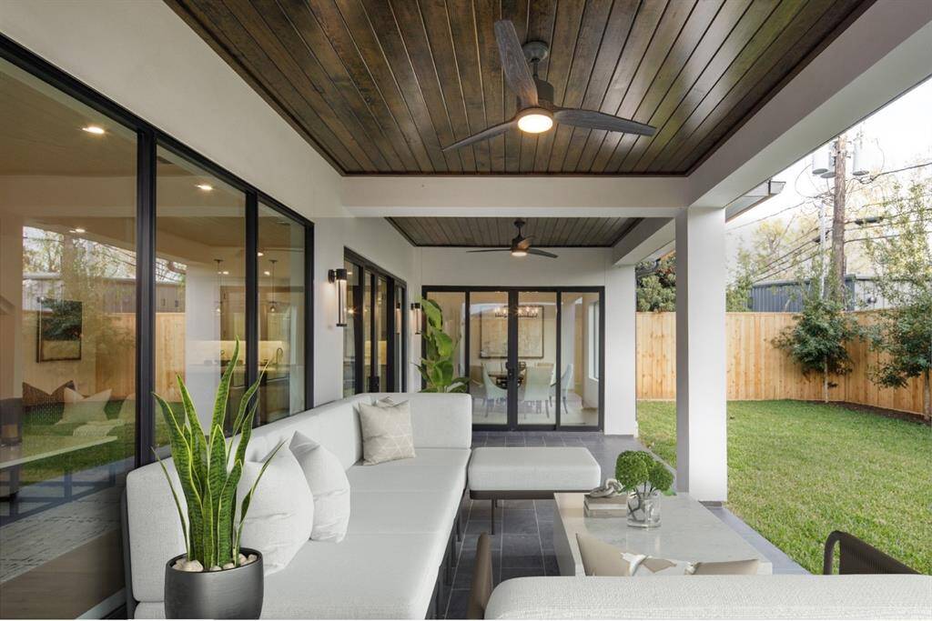 Outdoor covered deck with access to the breakfast room through a sliding glass door. Photo is virtually staged