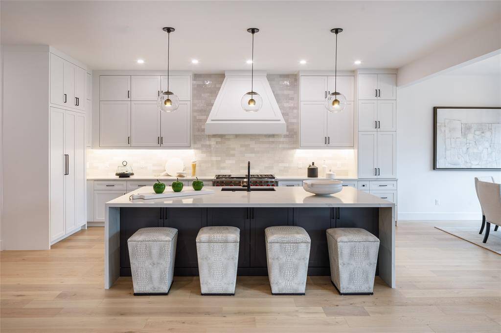 A dream kitchen with center island, stunning quartz countertop, breakfast bar with pull-out seating allowing a spot for gourmet meal or morning coffee