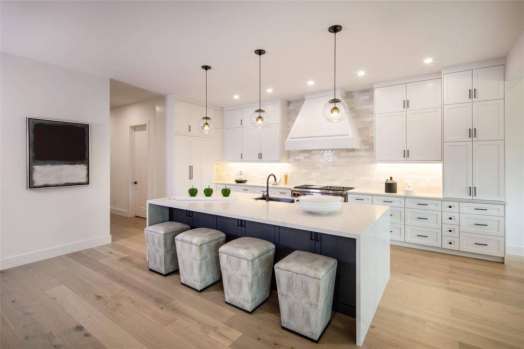 A kitchen with tone of chic, sophisticated and timelss elegance. Stylish statement pendent lights, custom-built cabinetry & storage. TOP-OF-THE-LINE appliances. Sub-zero Refrigerator/freezer, Wolf and Bosch appliances.
