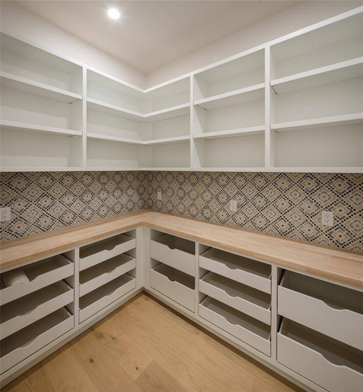 Large custom designed walk-in pantry with decorative tile back splash, abundant storage and easy access to the kitchen
