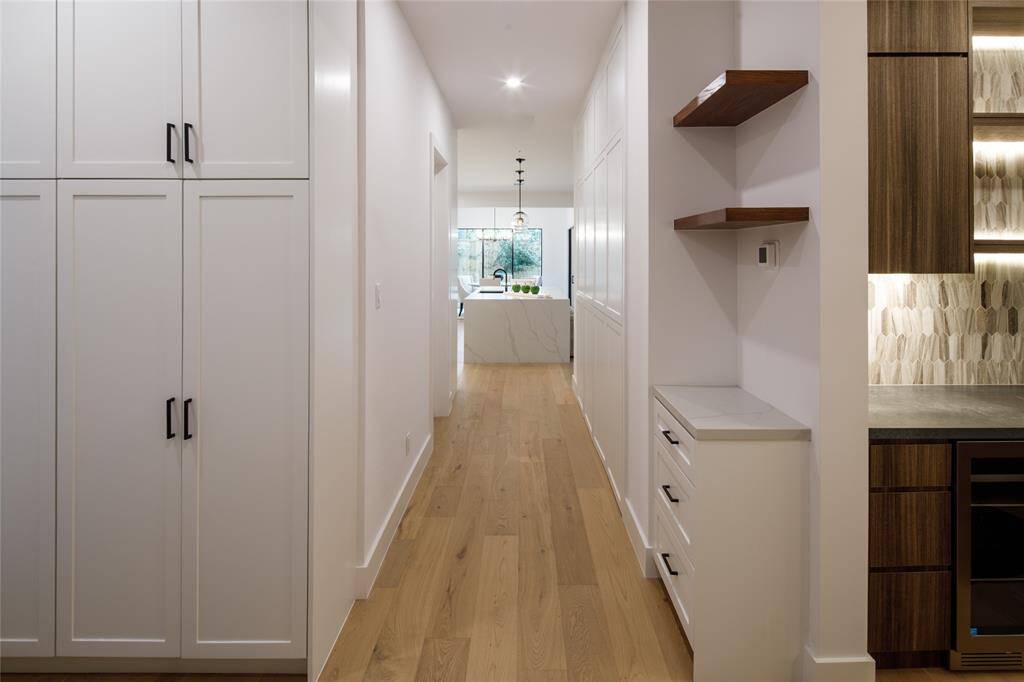Storage galore through a hallway leading to the mud room for busy families conveniently located next to the garage door and side door to the exterior