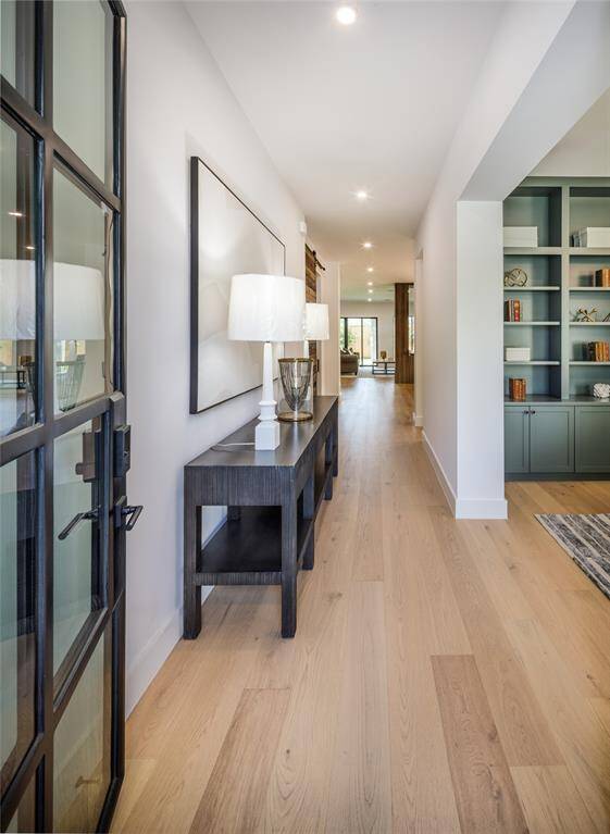 There is nothing more welcoming than a chic foyer entry with elegant glass & wrought iron front door.