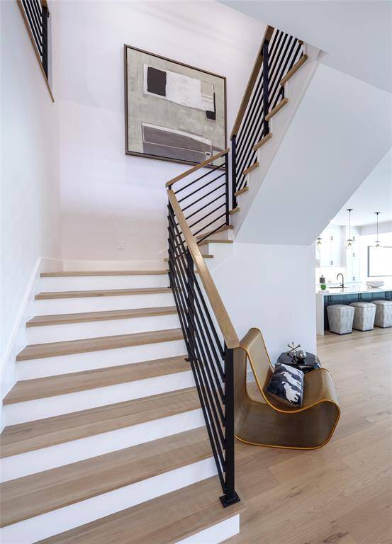 Modern floating staircase with balusters and wrought iron railing