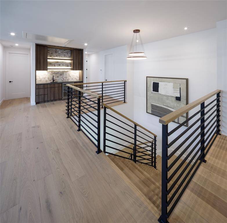 An extension to the game room allowing more entertainment space for your guests. Custom-built bar with sink, tile backsplash, wind & beverage refrigerator and open concept shelves.