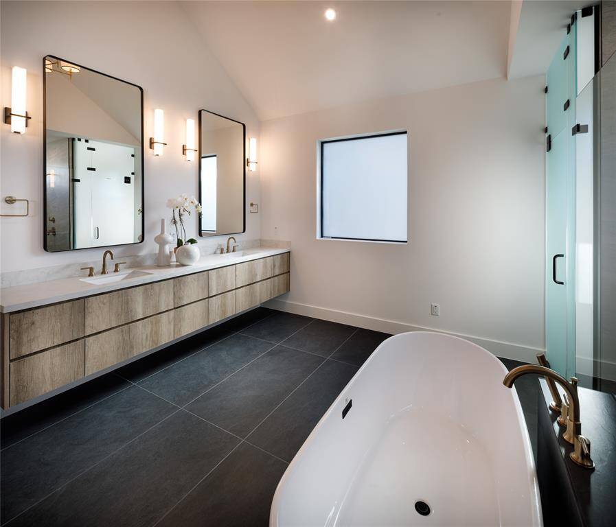 This elegant primary bathroom that you can love to improve your mood and boost your relaxation. Featuring quartz counter-tops, floating vanity with double sinks and wall sconces surrounding framed mirrors. Spacious enough allowing seated changing area