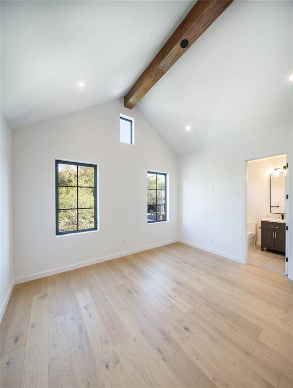 Secondary En-suite bedroom with front yard views and ceiling beams