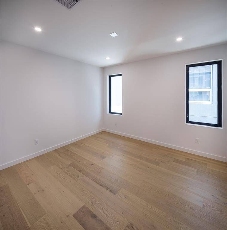 One of the three en-suite guest bedrooms. Engineered hardwood floors throughout