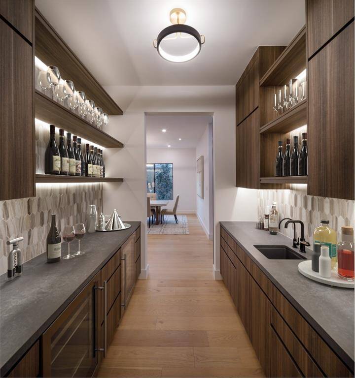 Butler's pantry and wet bar designed to sit conveniently and separate from the dining room. Beverage refrigerator, Wine chiller, water purifier and custom-built cabinetry offering additional storage advantage. Photo is virtually staged
