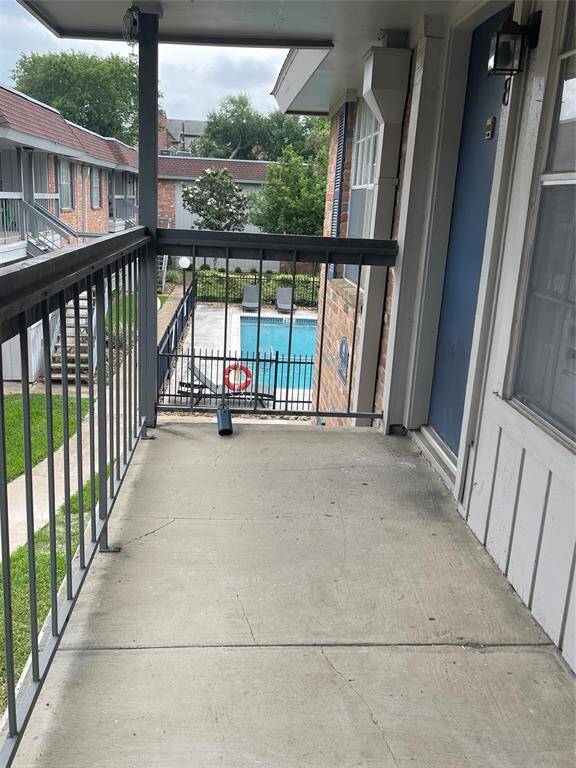 Welcome to 2250 Bering #98—this second-floor walkway has a view of a swimming pool and the surrounding courtyard area. This setting is quiet and features greenery, offering a pleasant community atmosphere.